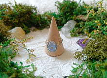 Load image into Gallery viewer, Ring on a cone surrounded by greenery and crystals
